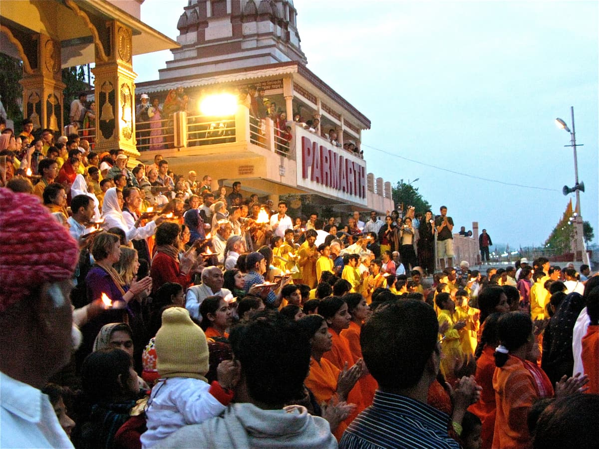 A crowd gathered for the evening Ganga Aarti at an ashram ghat in Rishikesh