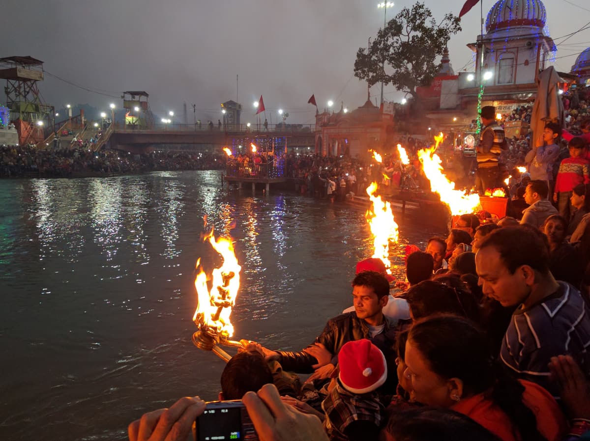 Worshippers holding flaming lamps beside the Ganga during the aarti at Har Ki Pauri